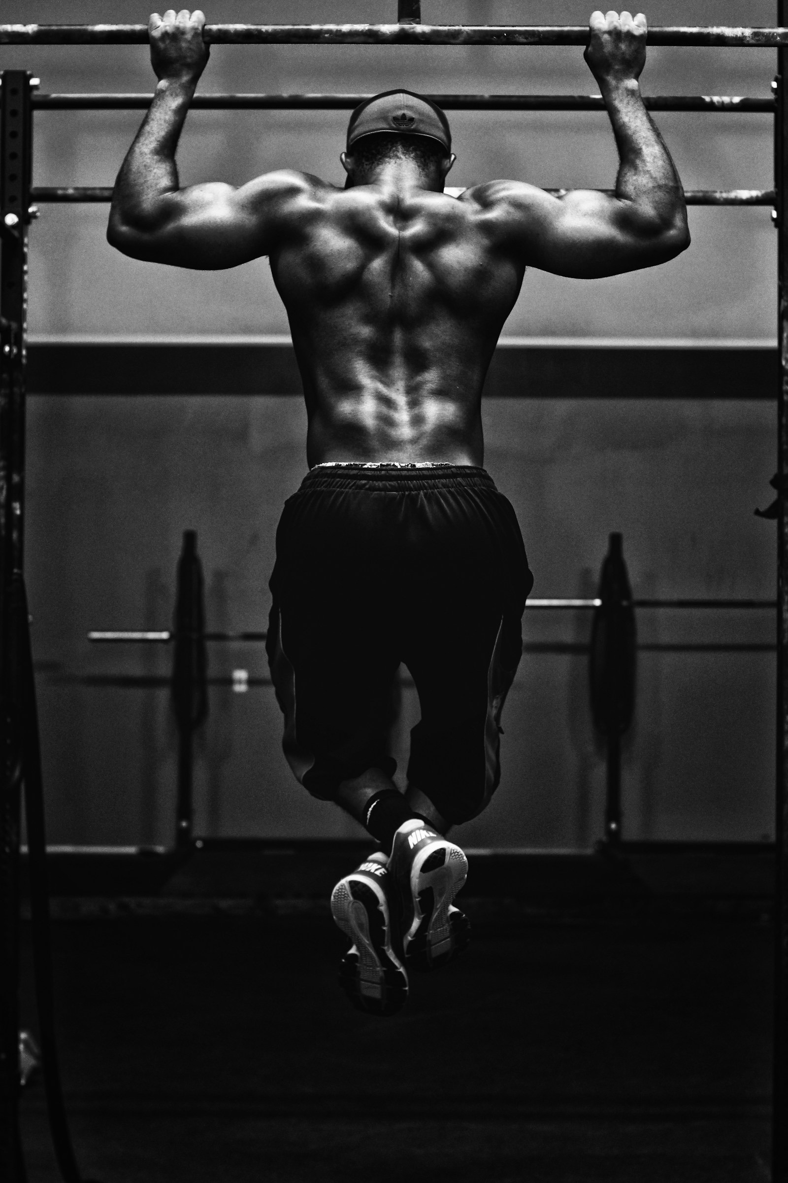A lifter resting between sets beside a loaded barbell in a gym